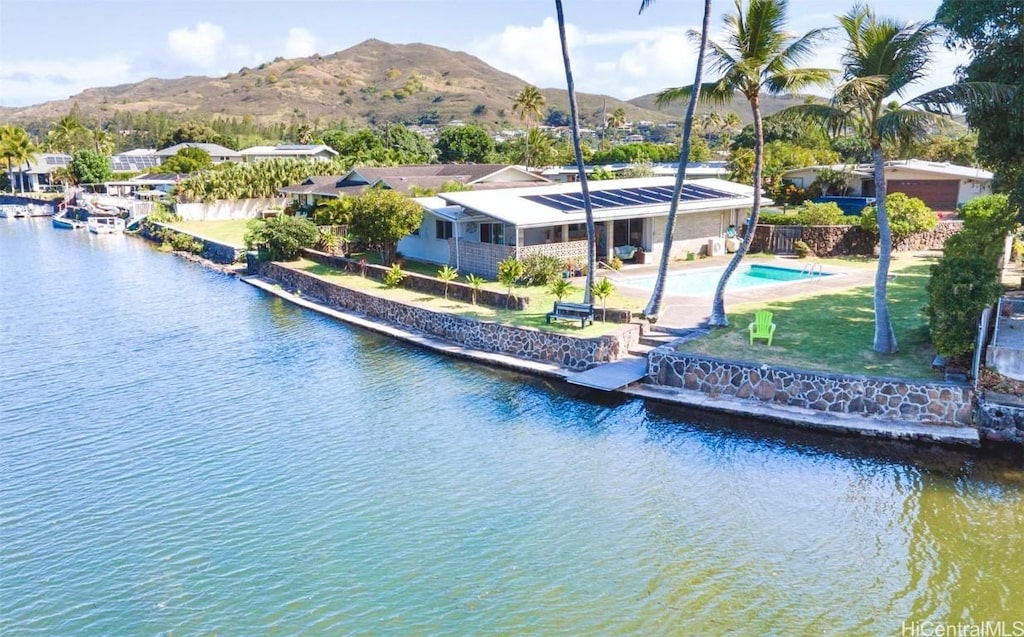 exterior space with a patio area, a yard, and a water and mountain view