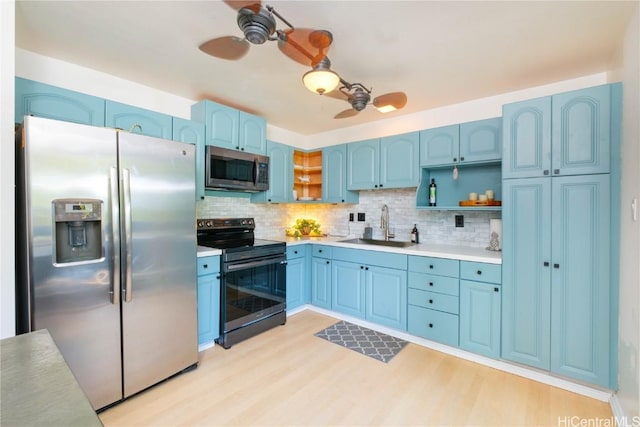 kitchen featuring stainless steel appliances, sink, backsplash, ceiling fan, and blue cabinets