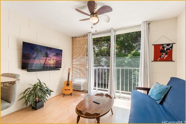 living room featuring a textured ceiling, hardwood / wood-style flooring, and ceiling fan