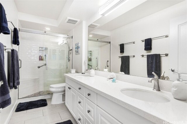 bathroom featuring tile patterned flooring, vanity, a shower with door, and toilet