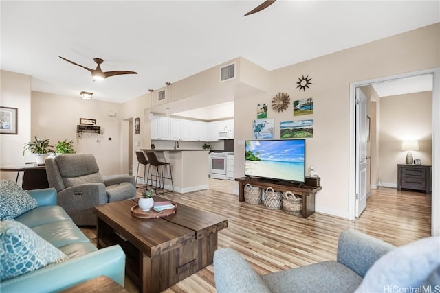 living room featuring ceiling fan and light hardwood / wood-style floors