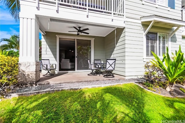 property entrance with a patio, a balcony, a yard, and ceiling fan