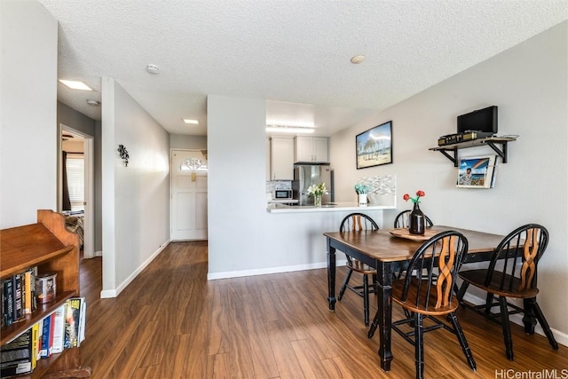 dining space featuring a textured ceiling and dark hardwood / wood-style flooring