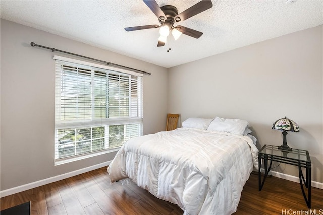 bedroom featuring ceiling fan, a textured ceiling, and dark hardwood / wood-style floors