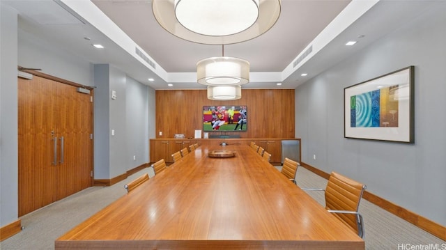 dining area featuring light carpet and a raised ceiling