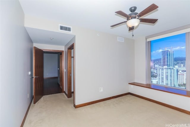 carpeted spare room with ceiling fan