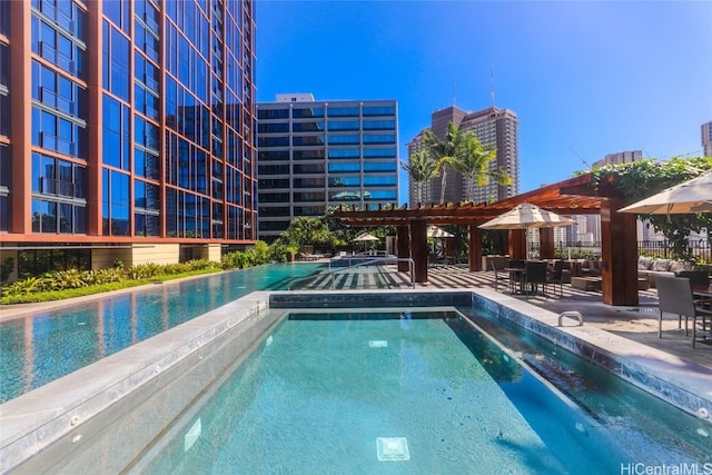 view of swimming pool featuring a pergola, a hot tub, and a patio