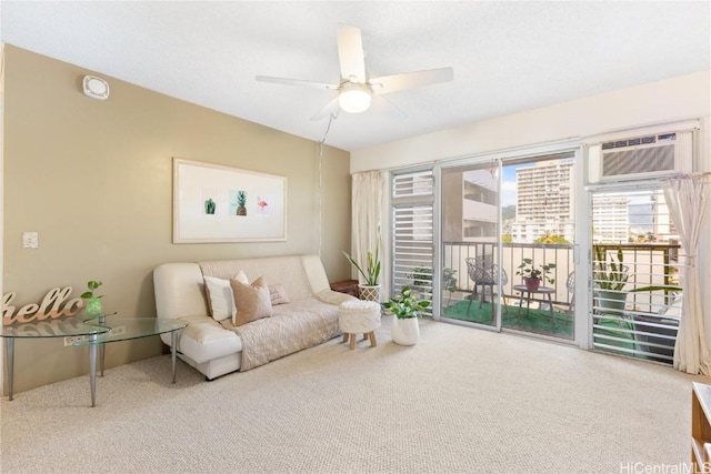 sitting room featuring a wall mounted AC, ceiling fan, and carpet flooring