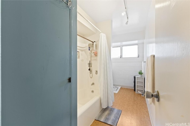 bathroom with track lighting and shower / bath combo