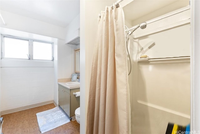 bathroom featuring vanity, walk in shower, and toilet