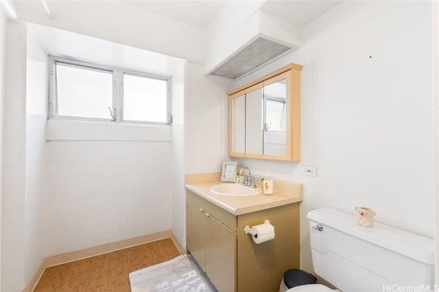 bathroom featuring vanity, toilet, and hardwood / wood-style floors