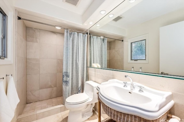 bathroom featuring toilet, backsplash, walk in shower, and tile walls