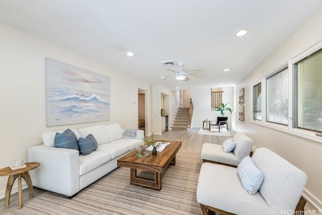 living room featuring ceiling fan and light hardwood / wood-style flooring