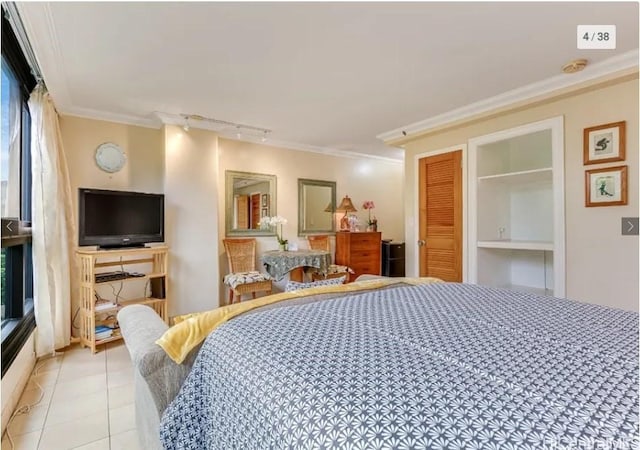 tiled bedroom with rail lighting, a closet, and crown molding