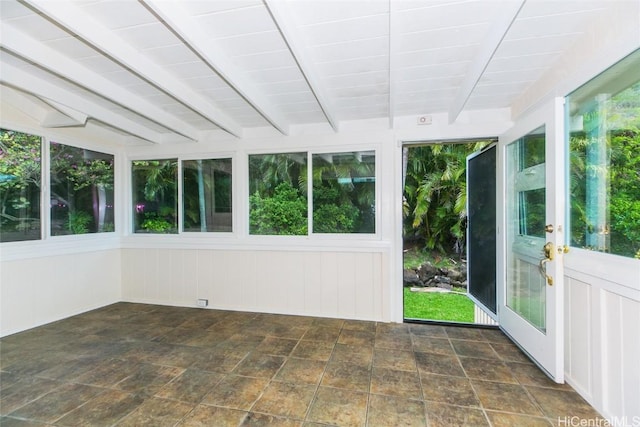 unfurnished sunroom featuring beam ceiling