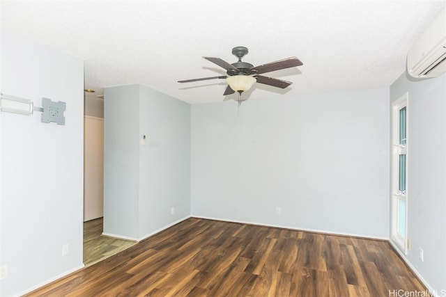 unfurnished room featuring an AC wall unit, dark hardwood / wood-style flooring, a textured ceiling, and ceiling fan