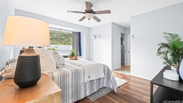 bedroom with baseboards, a ceiling fan, and wood finished floors