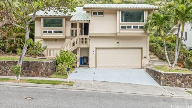 view of front of home featuring stucco siding, an attached garage, concrete driveway, and stairs