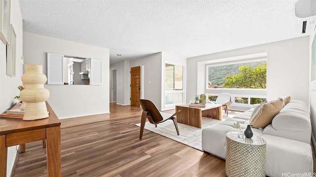 living area with a textured ceiling and wood finished floors