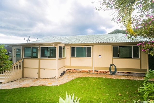 back of property with a lawn and entry steps