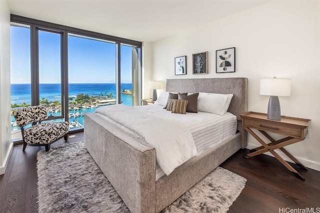 bedroom featuring floor to ceiling windows, dark wood-type flooring, multiple windows, and a water view