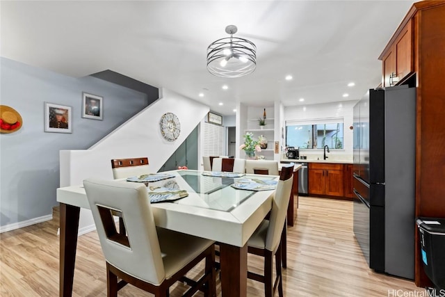 dining room featuring sink and light hardwood / wood-style floors