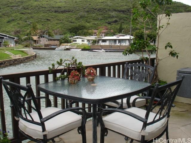 balcony featuring outdoor dining area and a water view