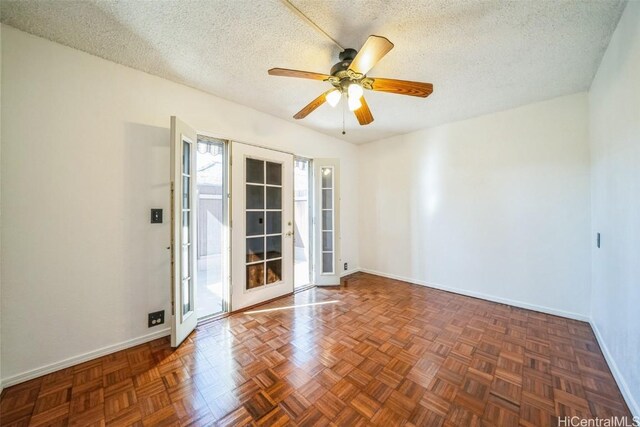 spare room with a ceiling fan, baseboards, and a textured ceiling