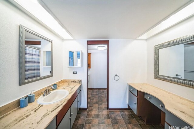 full bathroom featuring stone finish flooring and vanity