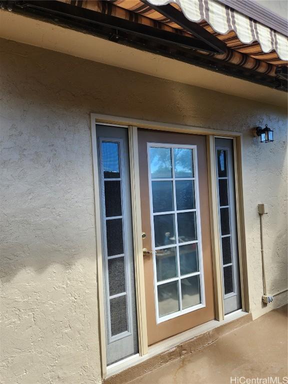 doorway to property featuring stucco siding