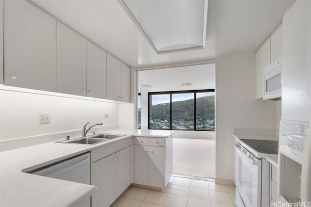 kitchen with sink, white appliances, and white cabinetry