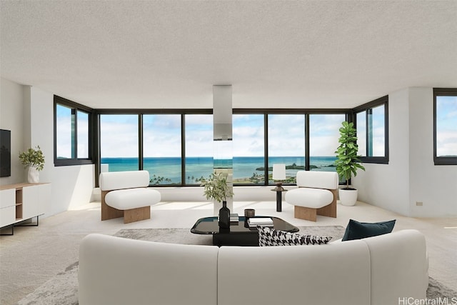 carpeted living room with a textured ceiling, a water view, and expansive windows