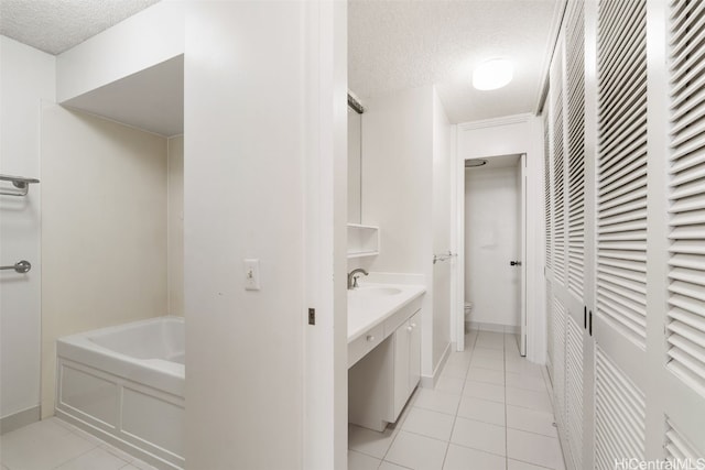 bathroom featuring a textured ceiling, sink, tile patterned floors, and toilet