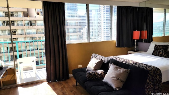 bedroom featuring wood finished floors and a city view