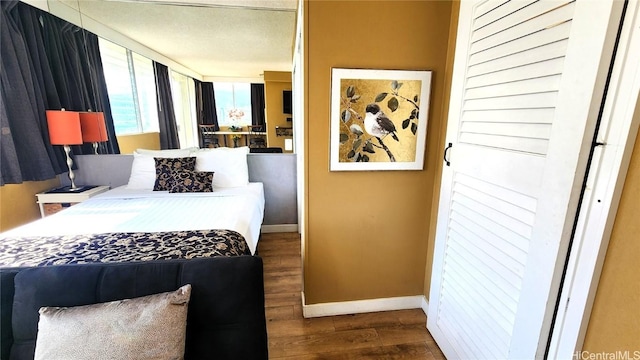 bedroom with dark wood finished floors and baseboards