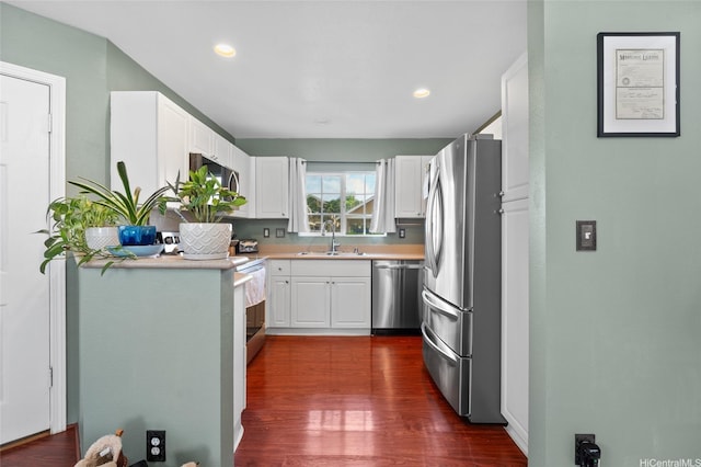 87-1980 Pakeke St Unit J, Waianae, HI 96792 - kitchen with appliances with stainless steel finishes, a sink, light countertops, dark wood-style flooring, and white cabinets