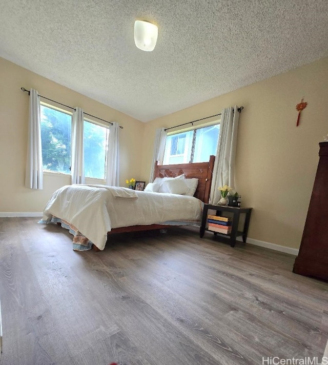 bedroom with a textured ceiling and hardwood / wood-style floors