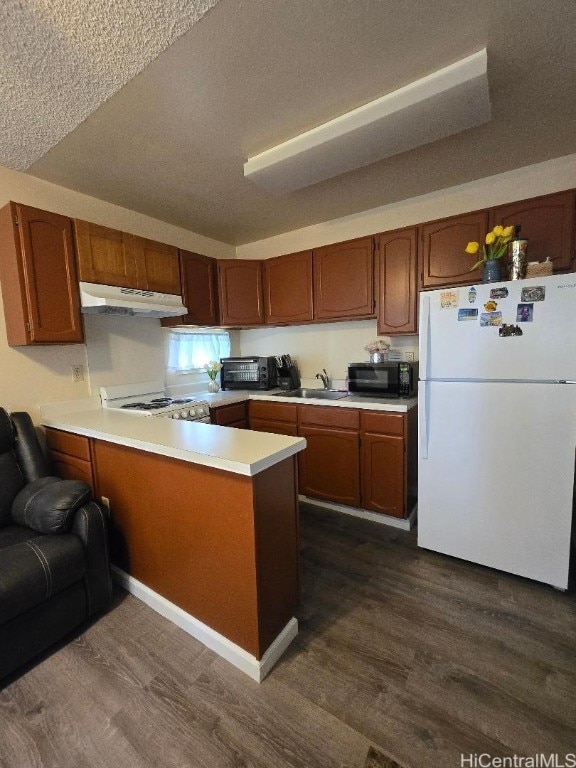 kitchen featuring kitchen peninsula, dark wood-type flooring, sink, and white refrigerator