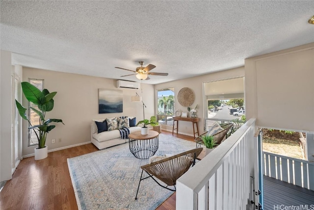 living room featuring ceiling fan, dark hardwood / wood-style floors, a textured ceiling, and a wall unit AC