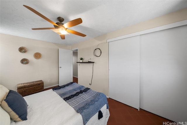 bedroom with a closet, ceiling fan, and a textured ceiling