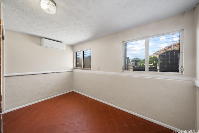 empty room with a textured ceiling and a wall unit AC