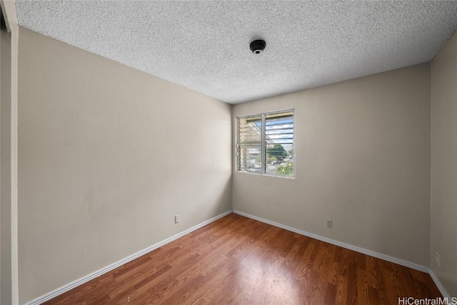 empty room featuring a textured ceiling and wood-type flooring