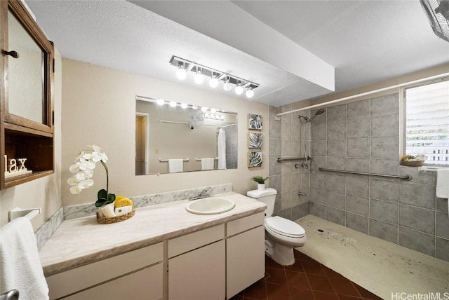 bathroom with vanity, toilet, tile patterned floors, and a tile shower