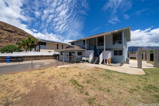 rear view of property featuring a patio area, central air condition unit, and a yard