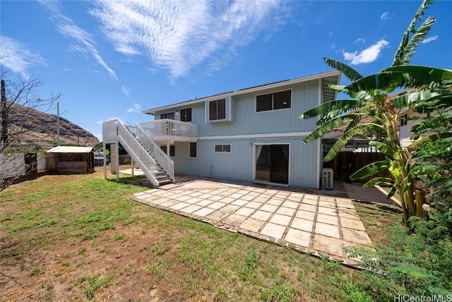 back of property with a lawn and a patio