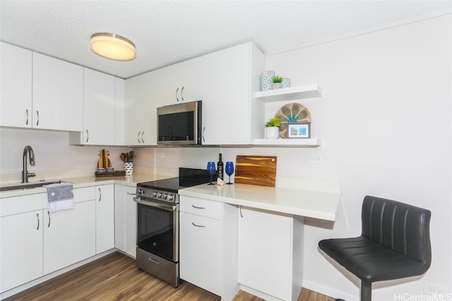 kitchen with white cabinets, a textured ceiling, appliances with stainless steel finishes, and sink