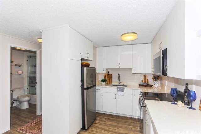 kitchen with white cabinets, sink, stainless steel appliances, and a textured ceiling