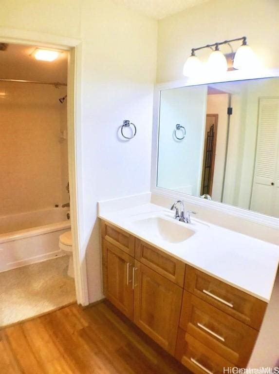 full bathroom featuring toilet, vanity, tub / shower combination, and hardwood / wood-style floors