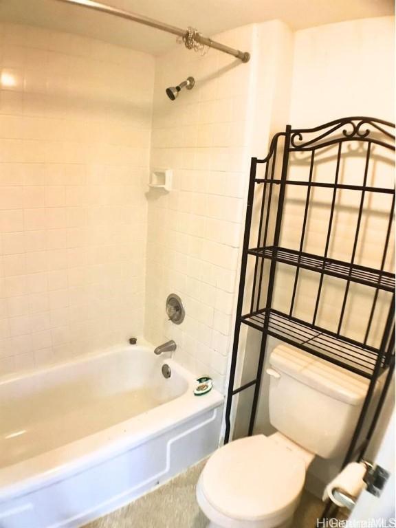 bathroom with toilet and tiled shower / bath combo