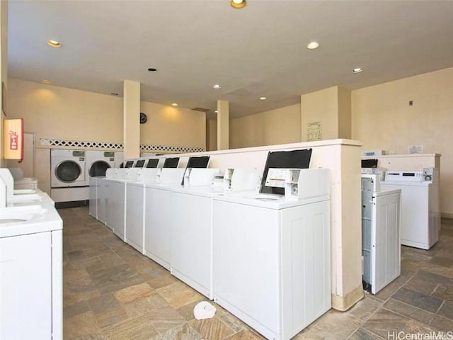 common laundry area with recessed lighting, stone finish floor, electric panel, and washer and clothes dryer
